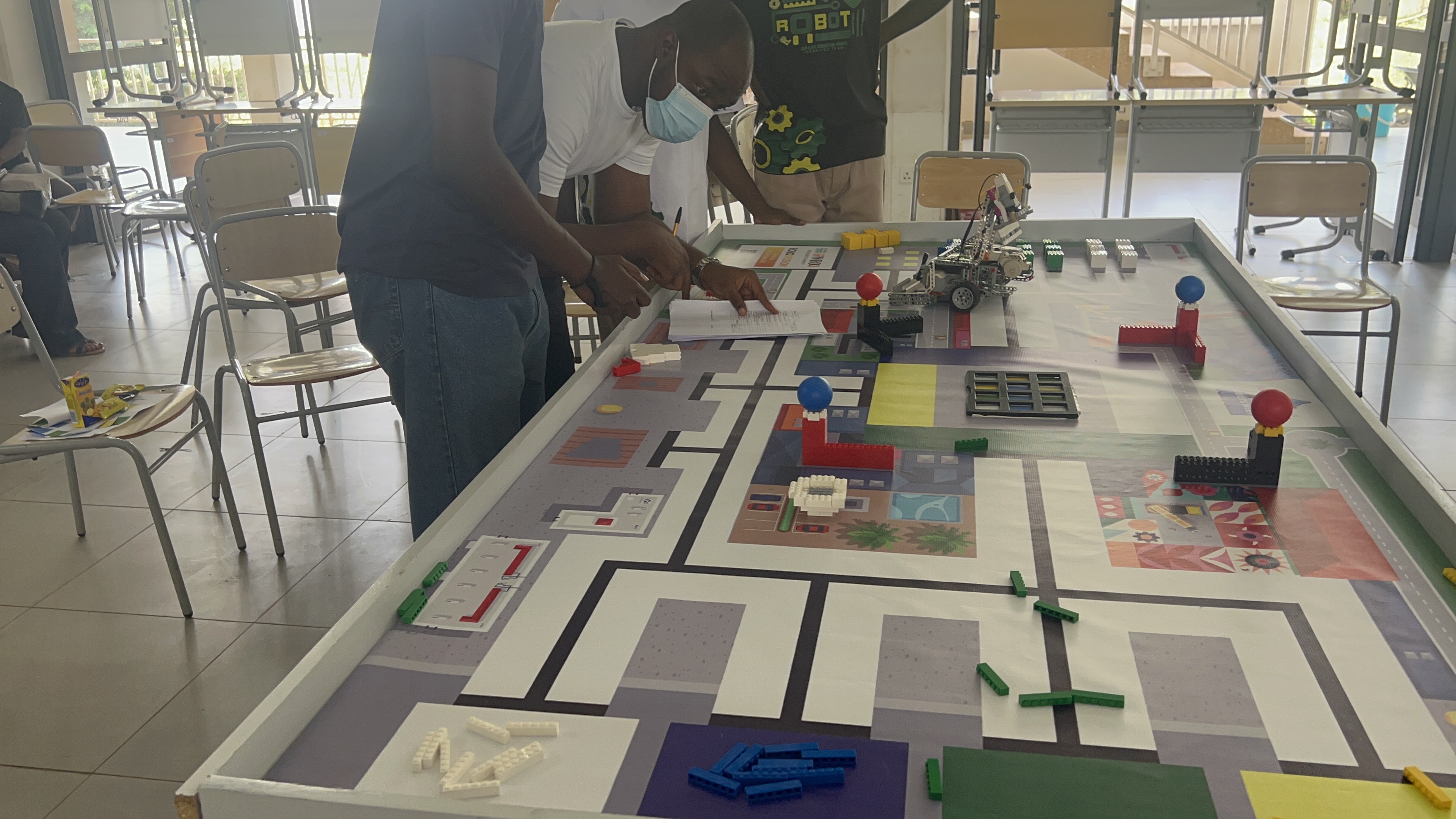 iTop Robotics mentors planning with students around a robotics competition table